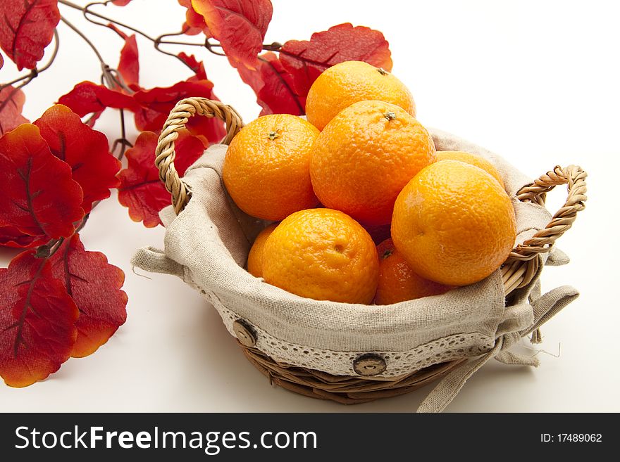 Tangerines in the basket with branch and leaf