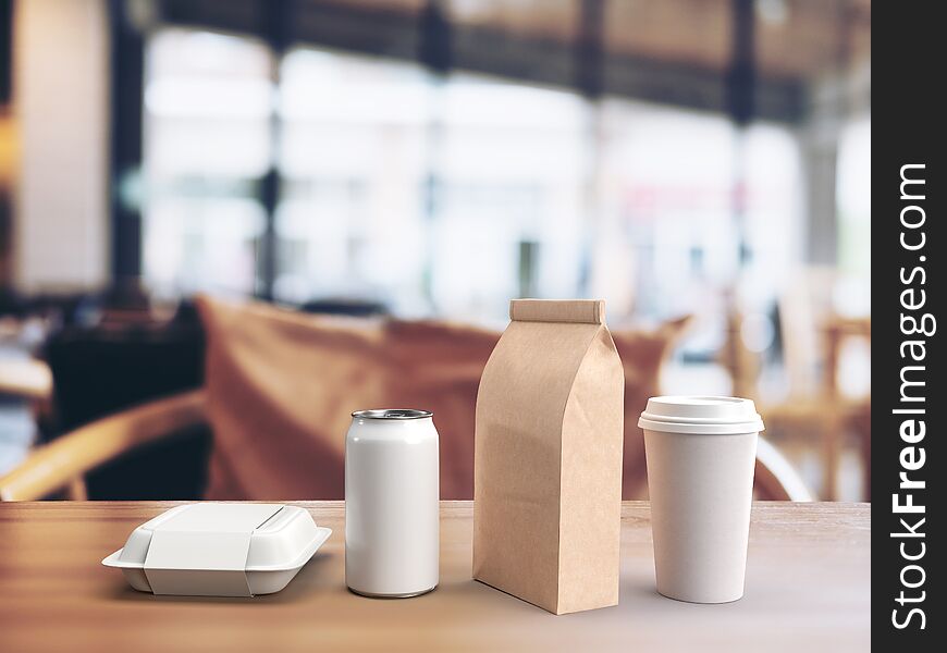 3d render of white mockup of a takeout lunch box, beverage can, paper coffee bag and coffee mug on a wooden table in a blurred restaurant background.