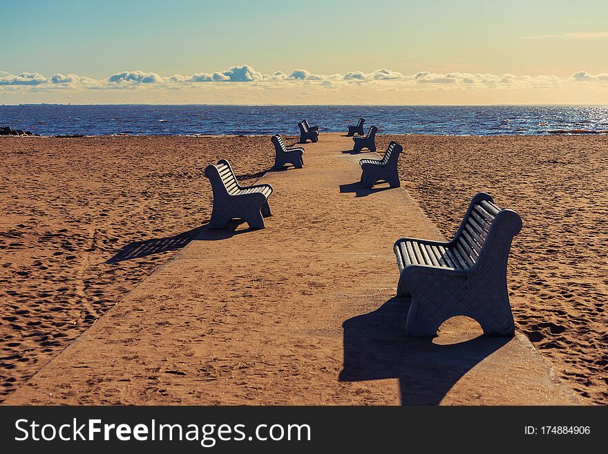 Benches on the road to the beach on a sunny winter day, deserted Beach Laskovy in Saint-Ptersburg, Russia