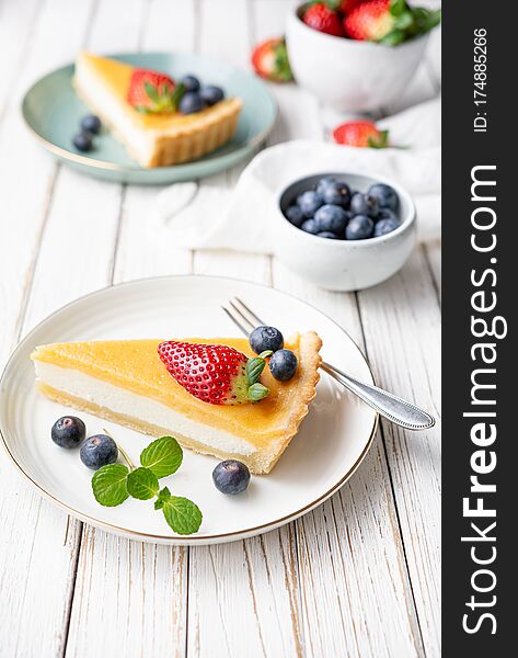 Cream Cheese Tart Slices With Lemon Curd Topping, Served With Fresh Blueberries And Strawberries