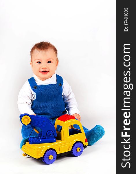 Happy little boy playing with cars and toys.