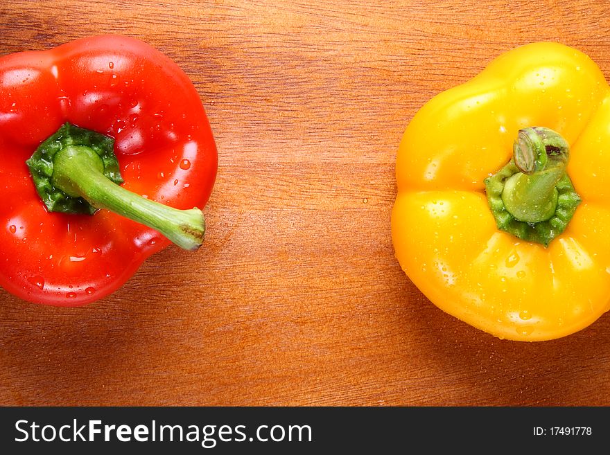 Image of two peppers on wooden hard board. Image of two peppers on wooden hard board