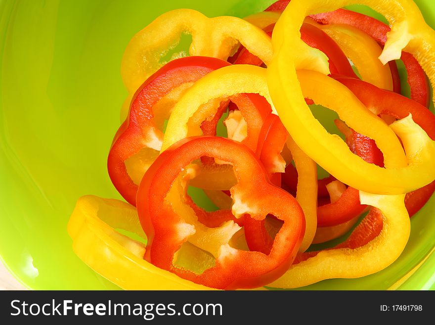 Sliced sweet peppers on bright green background