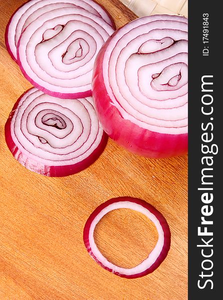 Image of sliced red onion over wooden hard board