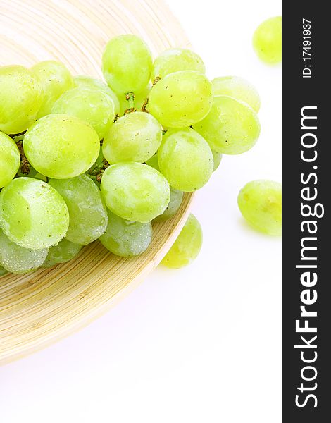 Image of grape on wooden plate over white