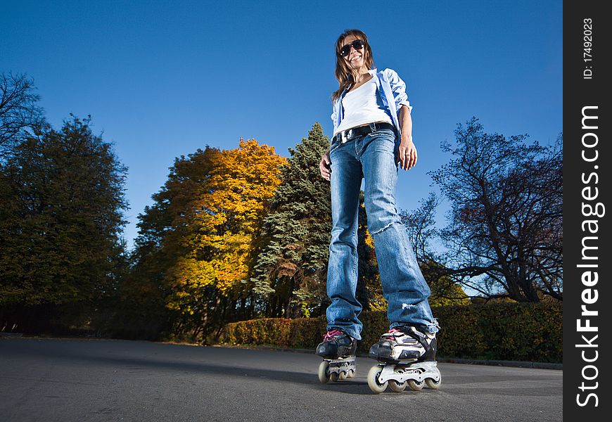 Wide-angle shot of a happy rollerblading girl
