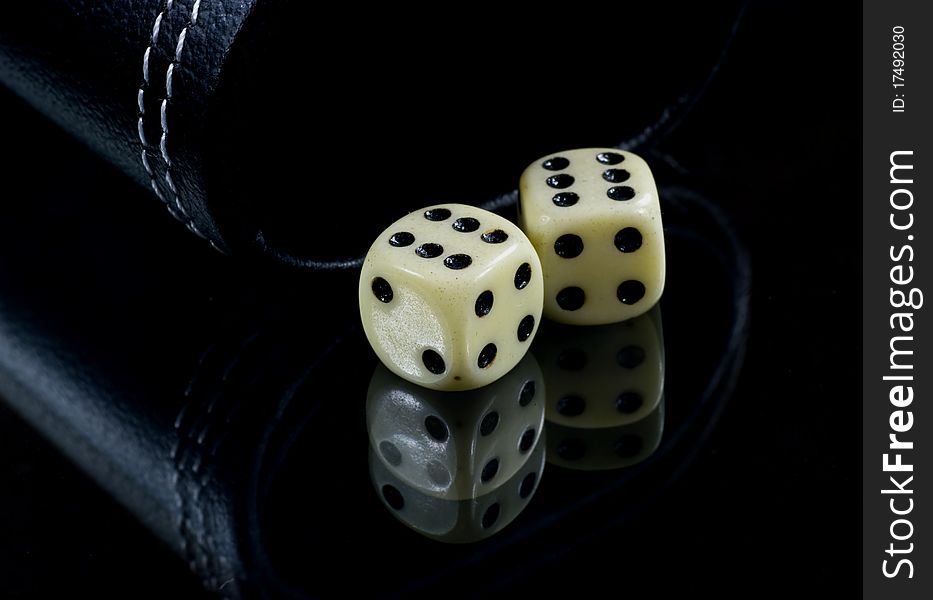 Two standard six-sided pipped dice with rounded corners on black background. Two standard six-sided pipped dice with rounded corners on black background.