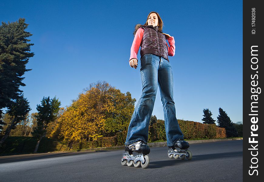 Wide-angle shot of a happy rollerblading girl