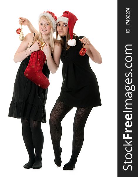 Two girls in the Santa hat and gifts on white background