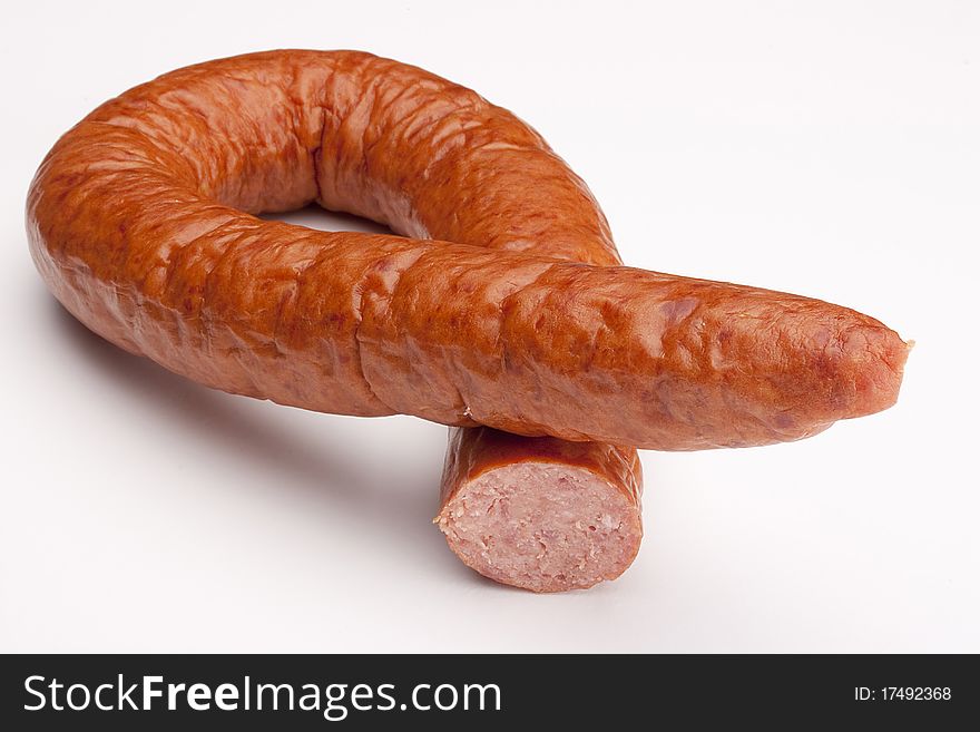 Fatty home smoked sausage on a white background.