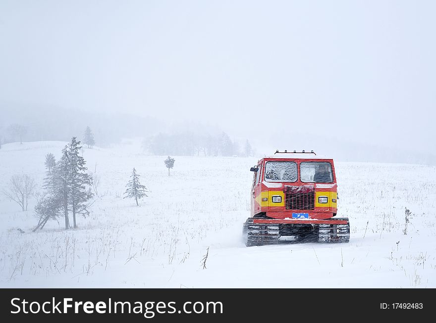 A marching tractor goes in the snowstorm. A marching tractor goes in the snowstorm