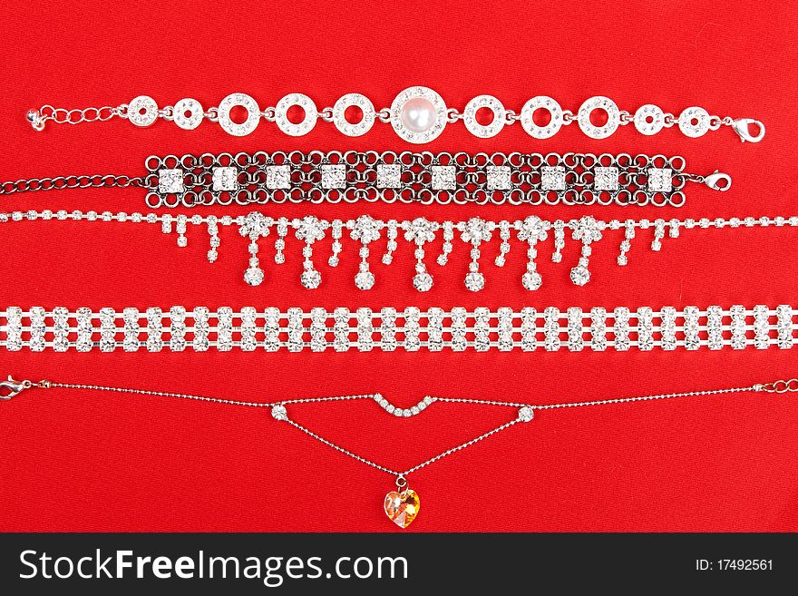 Women's bracelets and a necklace on a red fabric background