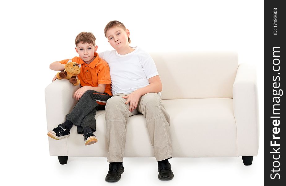 Two brothers sitting on a sofa on a white background