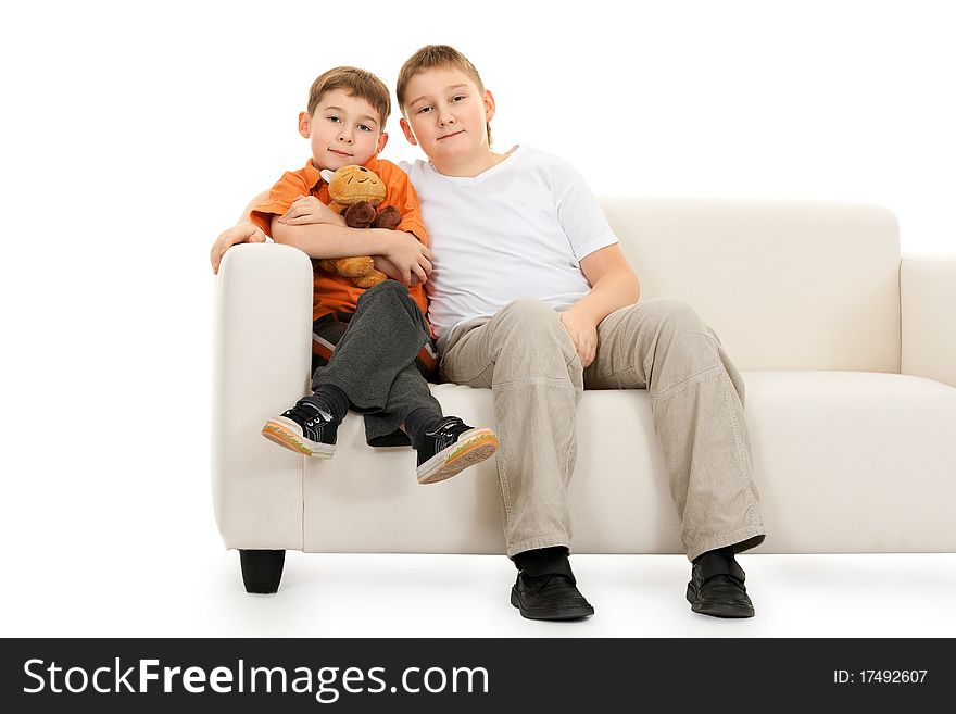 Two brothers sitting on a sofa on a white background