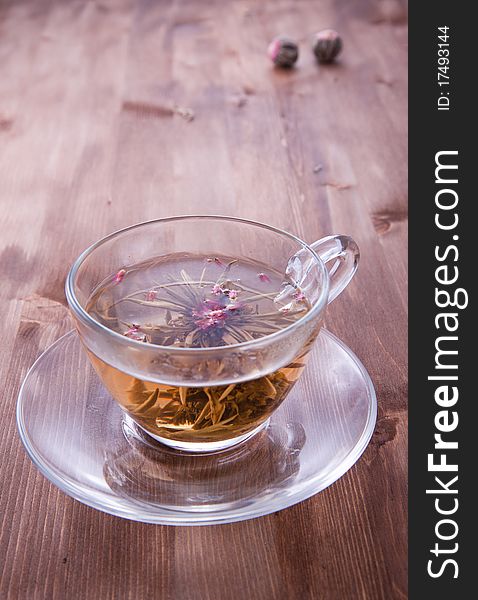 Transparent cup of green tea on the wooden table