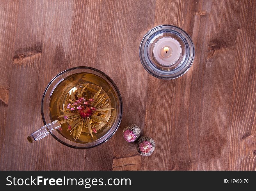 Transparent cup of green tea and burning candle