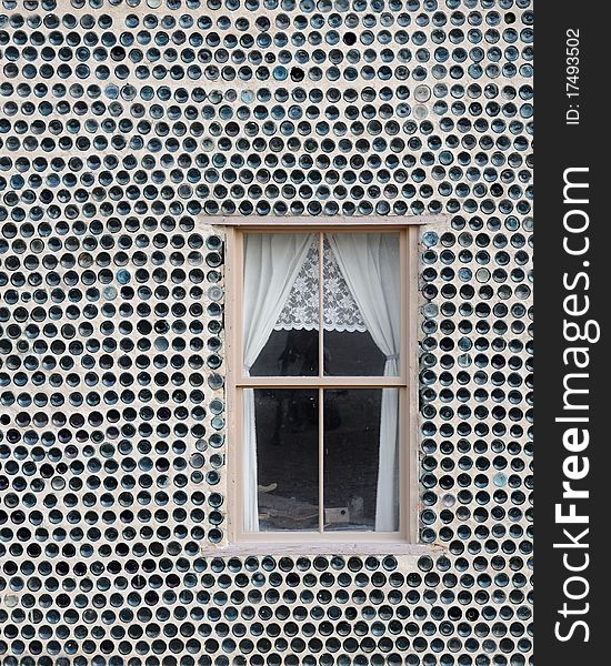 Window surrounded by wall made of bottles. Window surrounded by wall made of bottles