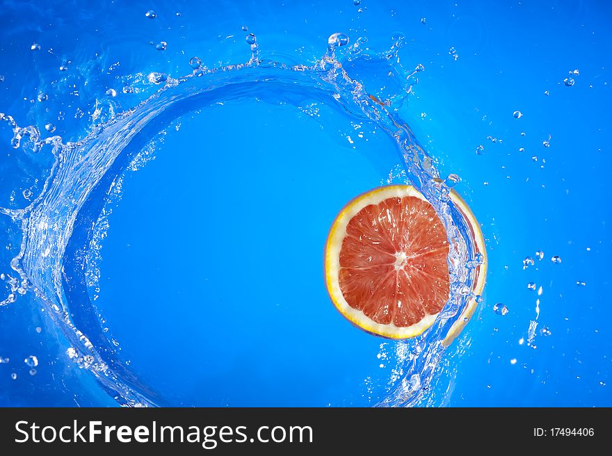 Fresh orange and splashing blue water