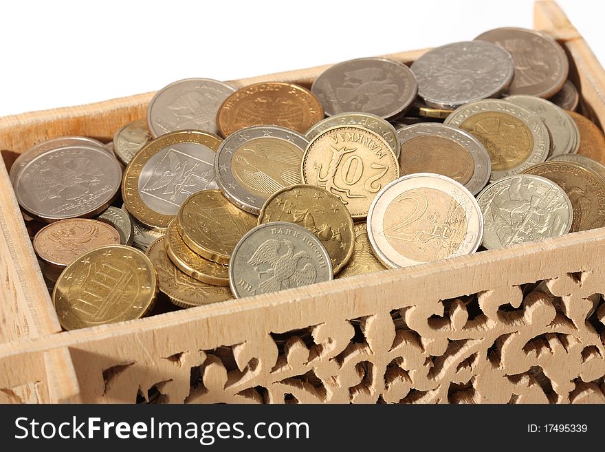 Close-up of carved wooden box filled with coins isolated on white