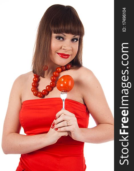 Fashion beautiful model dressed in the red dress stand with a tomato necklace, fork and isolated on a white background. Fashion beautiful model dressed in the red dress stand with a tomato necklace, fork and isolated on a white background