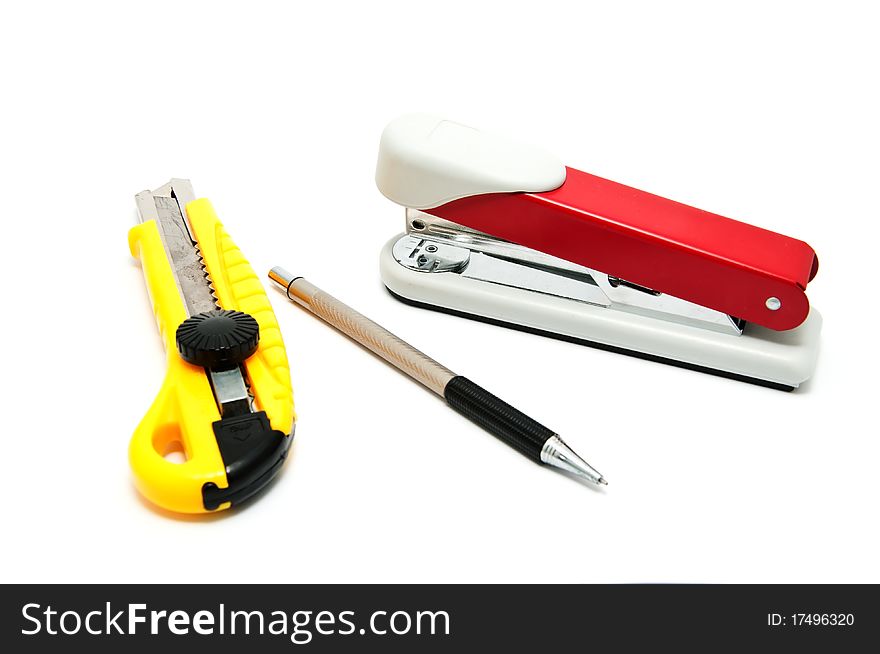 Several Office devices on a white background (stapler, knife, pen)