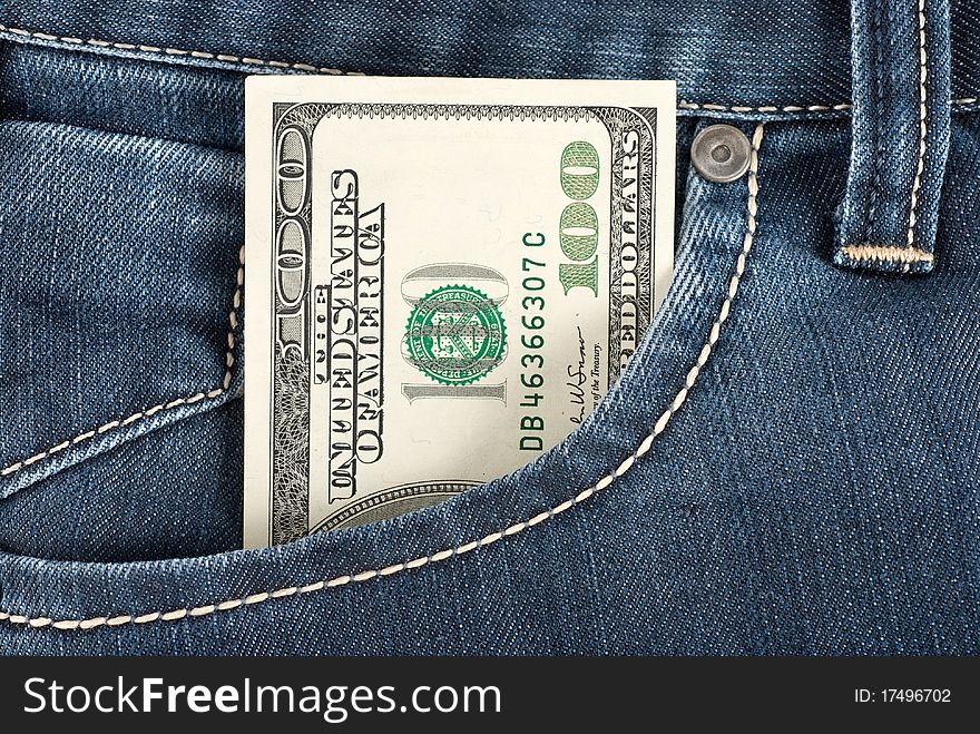 A one hundred dollar note in the front pocket of denim trousers. A one hundred dollar note in the front pocket of denim trousers