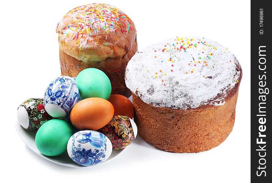 Multi-colored eggs on a plate and cakes. Easter holiday. Isolated on a white. Multi-colored eggs on a plate and cakes. Easter holiday. Isolated on a white