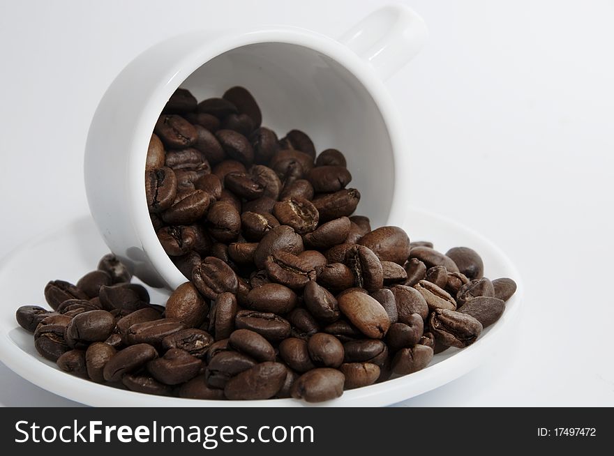 Cup with coffee beans on white background