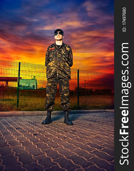 Man in camouflage at military base sunset. Man in camouflage at military base sunset