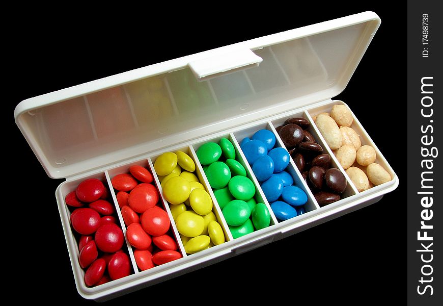 Pillbox filled with colorful candy and peanuts; black background. Pillbox filled with colorful candy and peanuts; black background.