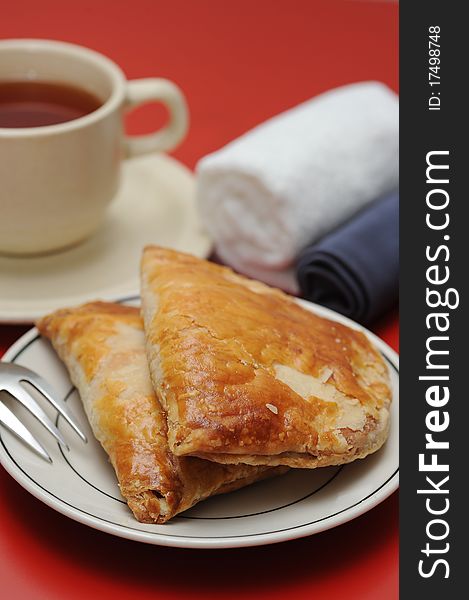 A cup full of hot tea and delicious puff pastry. A cup full of hot tea and delicious puff pastry.