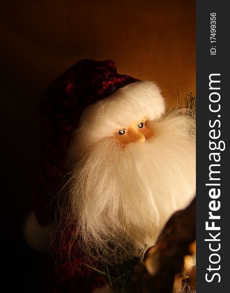 Santa doll looks thoughtfully into the warm glow, a clean and cozy background. Santa doll looks thoughtfully into the warm glow, a clean and cozy background.