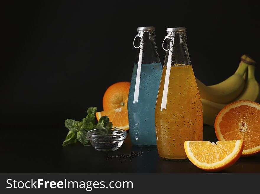 Trendy tropical blue and orange drink with basil seeds in bottle on black background, Closeup, Copy space