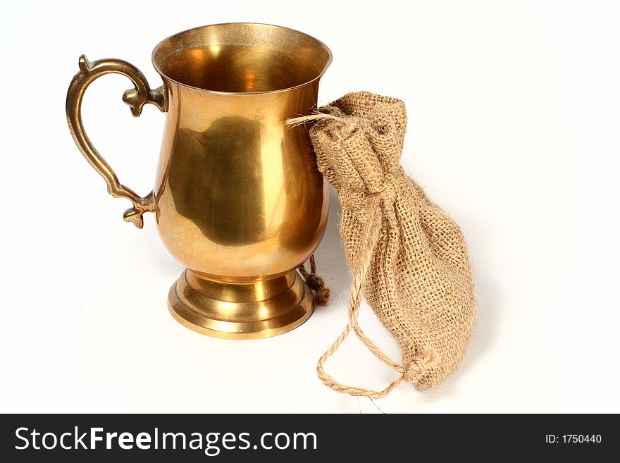 A brass cup and hessian bag. A brass cup and hessian bag.
