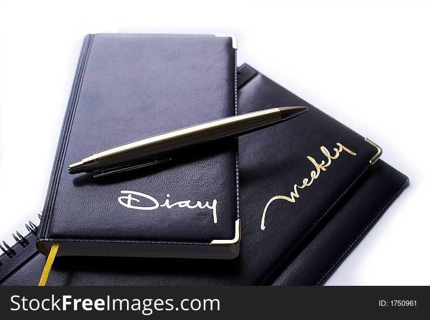 Office supplies: black diary, weekly and metal pen. Office supplies: black diary, weekly and metal pen