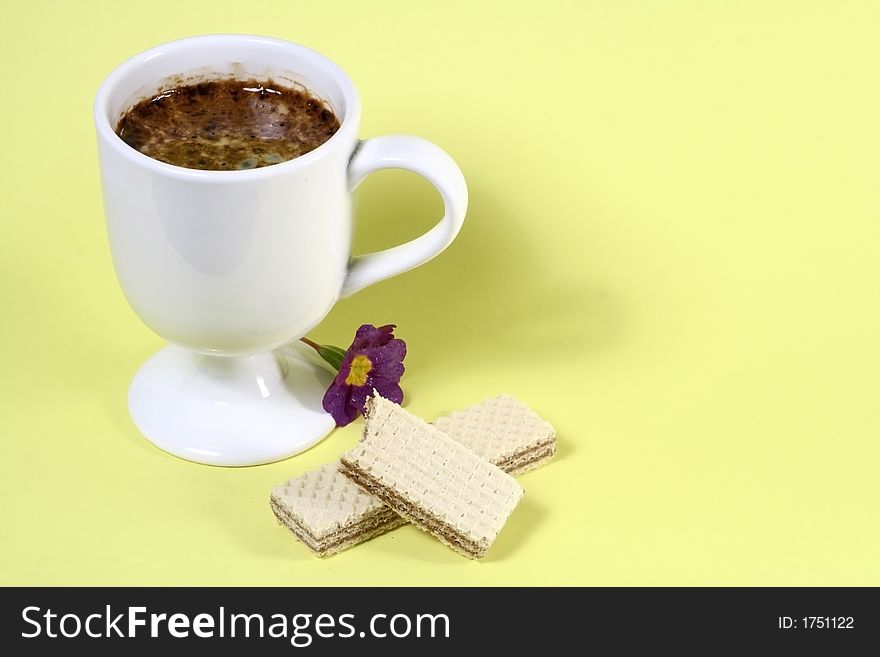 A cup of coffee and a wafer. A cup of coffee and a wafer.