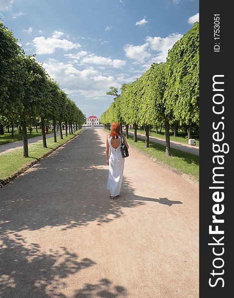 Woman in white, walking on Marli palace road in Peterhof,Russia. Woman in white, walking on Marli palace road in Peterhof,Russia