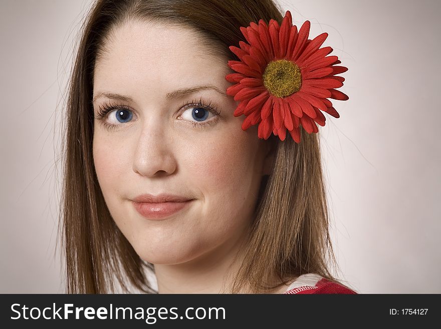 Woman poses with a pretty red flower. Woman poses with a pretty red flower