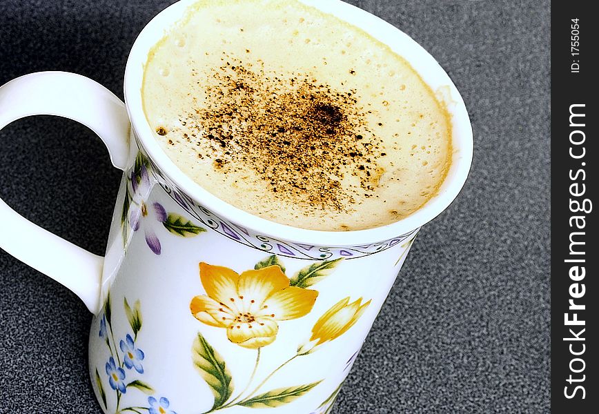 Beaker of cappuccino coffee sprinkled with chocolate powder. Beaker of cappuccino coffee sprinkled with chocolate powder