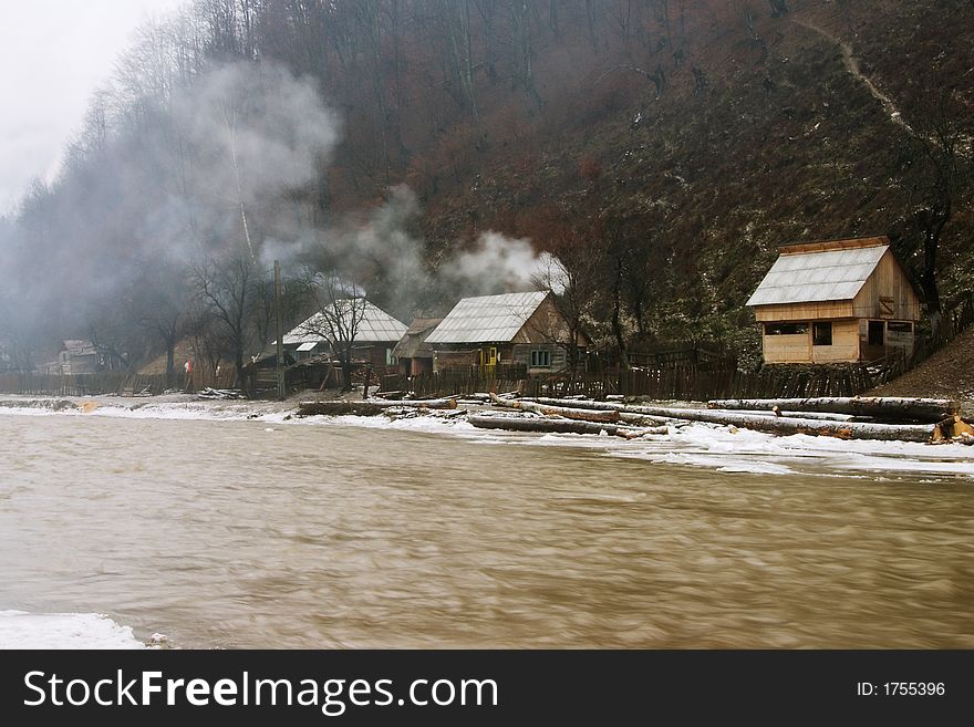 Isolated mountain houses near muddy river