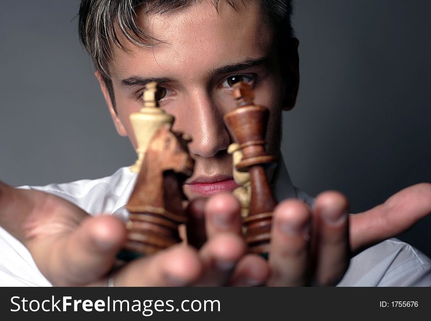 Very handsome young man concentrating on chess figures. Very handsome young man concentrating on chess figures