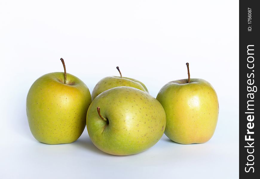 Four yellow apples over white