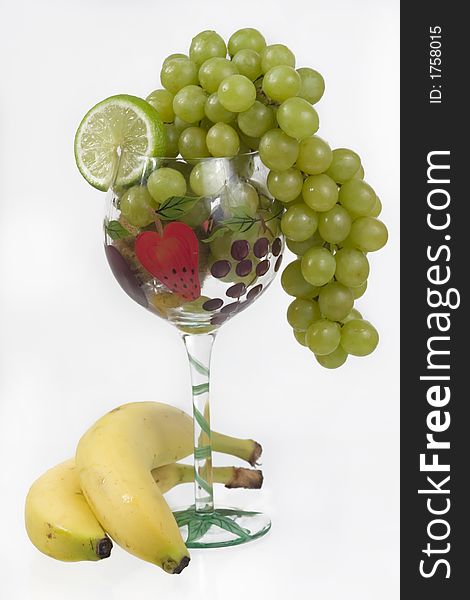 Grapes, lime, kiwi and banana in a fancy glass. Grapes, lime, kiwi and banana in a fancy glass