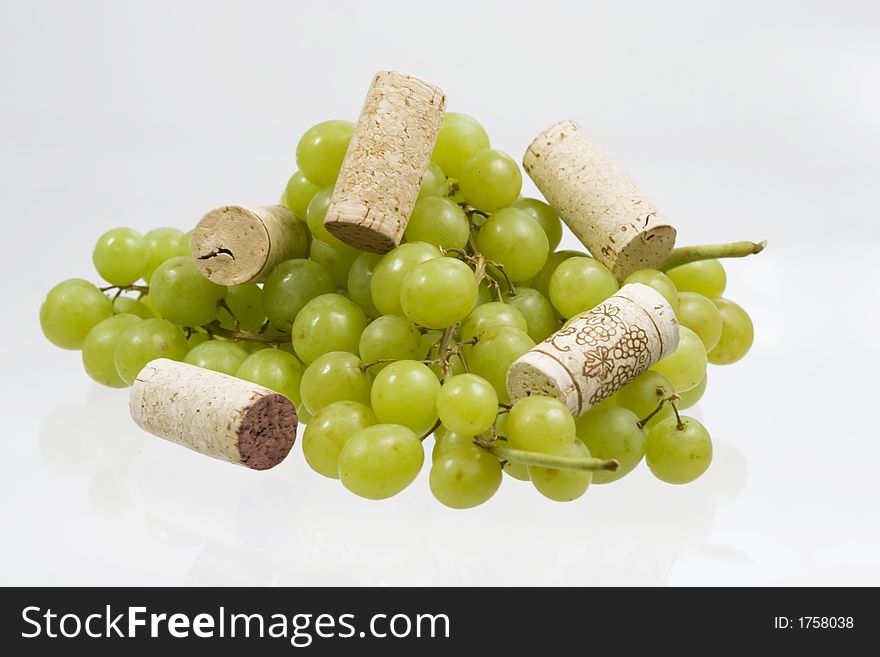 Grapes and wine corks over white background. Grapes and wine corks over white background