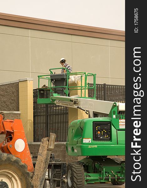 Construction worker on a hydraulic lift or cherry picker. Construction worker on a hydraulic lift or cherry picker