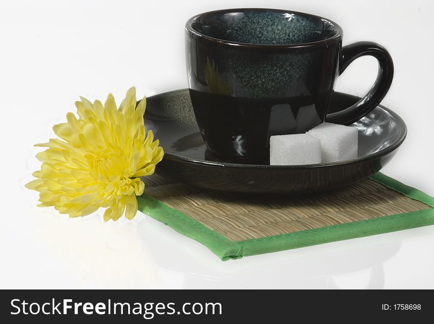 Green tiny coffee cup with sugar canes and a flower. Green tiny coffee cup with sugar canes and a flower