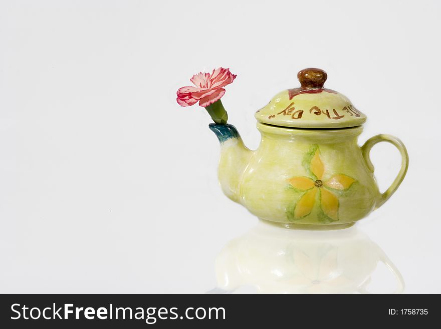 Green fancy kettle with a flower over white background. Green fancy kettle with a flower over white background