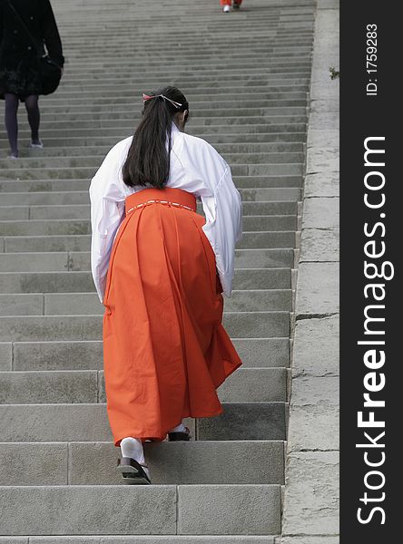 A Japanese lady in tradional costume walking up a steep sairway, Kamakura. Kanagawa-ken, Japan.