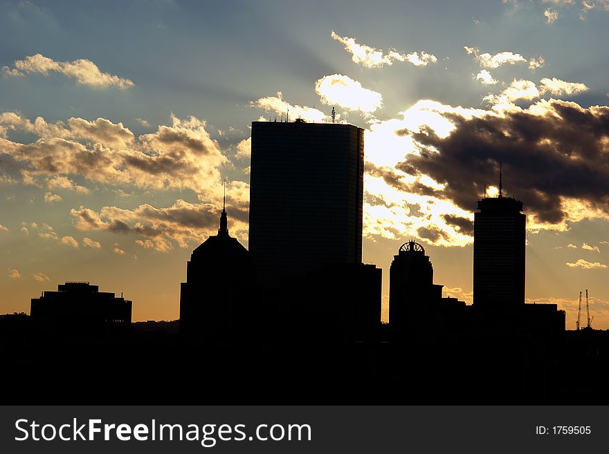 Boston's Skyscrapers silhouetted against the sky as the sun sets behind the clouds. Boston's Skyscrapers silhouetted against the sky as the sun sets behind the clouds