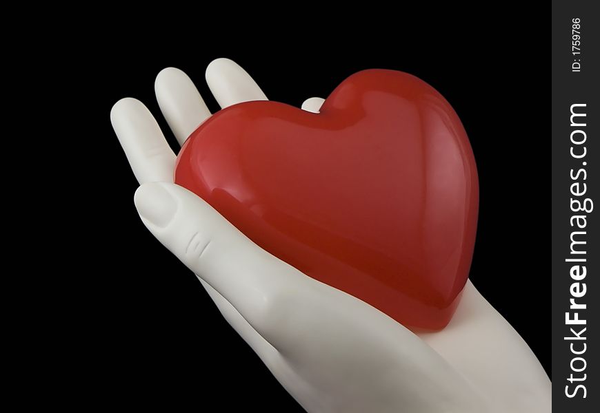 Photo of a hand holding a heart isolated on black. Photo of a hand holding a heart isolated on black